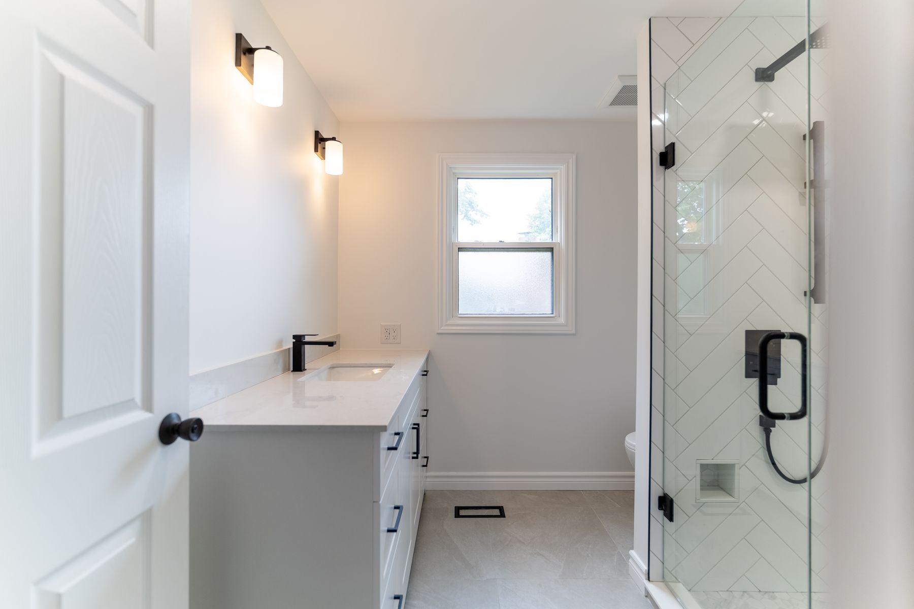 Herringbone tile bathroom renovation by Coronation Construction, photographed by Mike Mala
