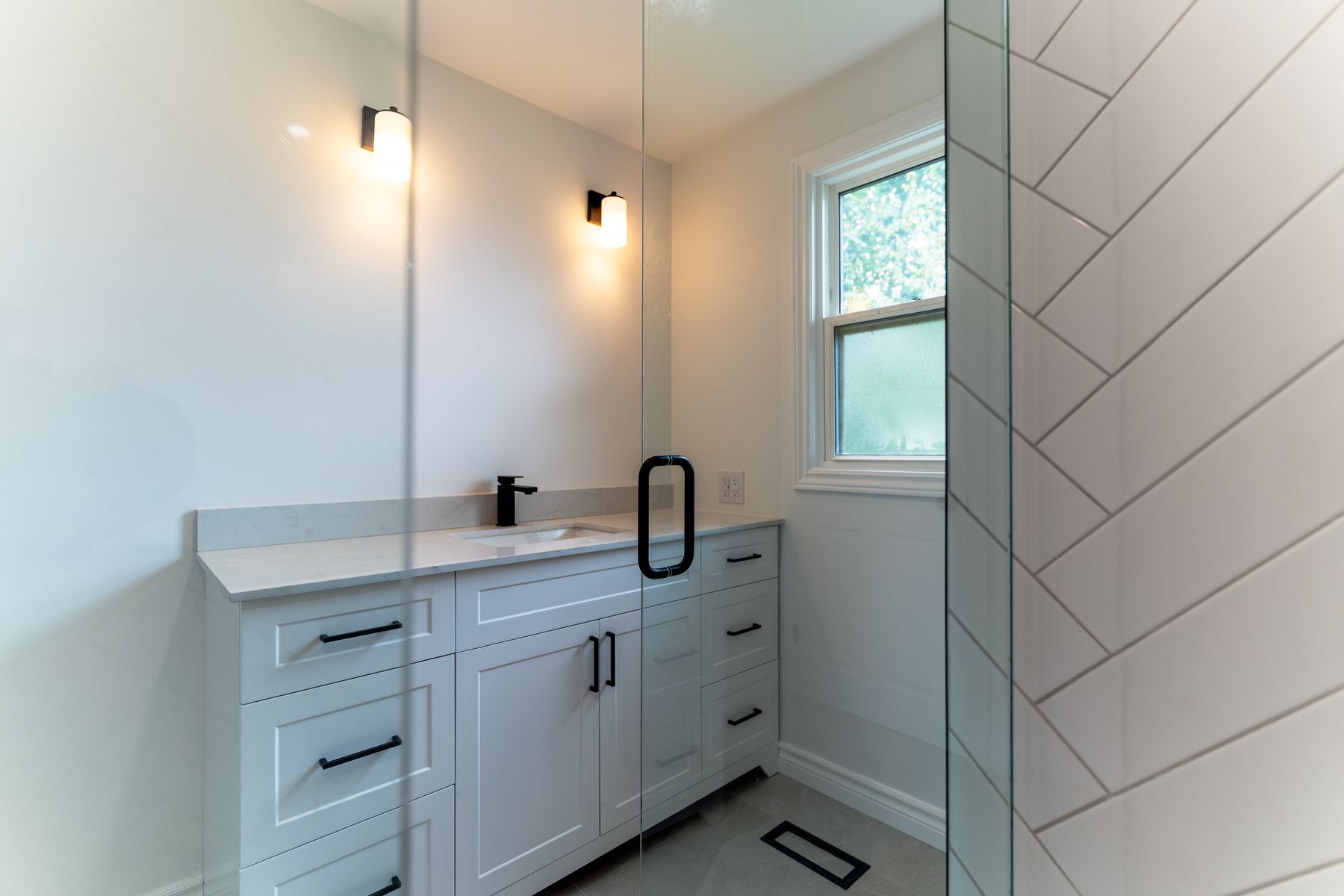 Herringbone tile bathroom renovation by Coronation Construction, photographed by Mike Mala