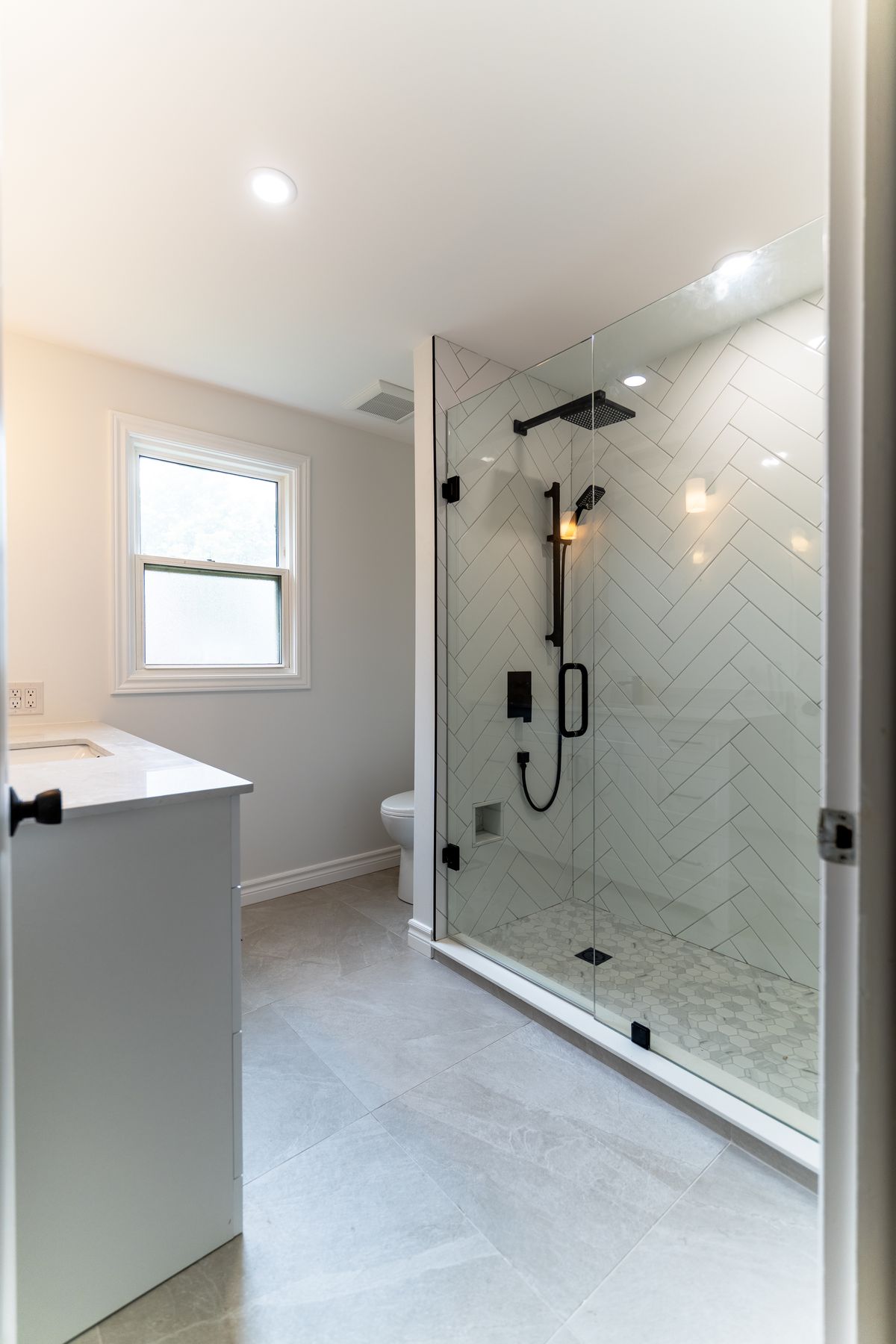 Herringbone tile bathroom renovation by Coronation Construction, photographed by Mike Mala